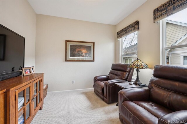 sitting room with baseboards and light colored carpet