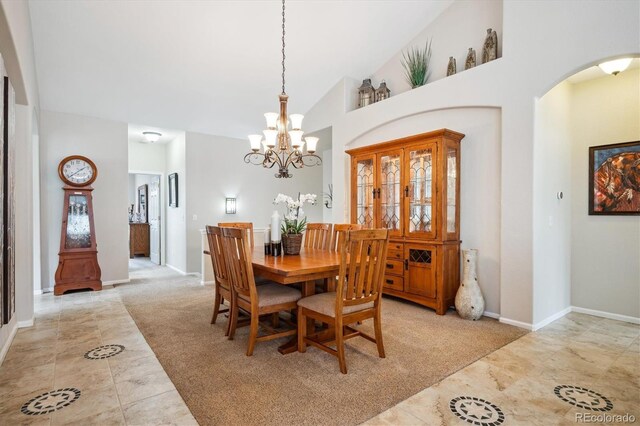 dining room with an inviting chandelier, arched walkways, high vaulted ceiling, and light carpet