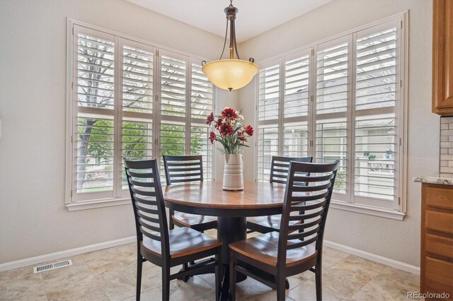 dining area featuring a healthy amount of sunlight, baseboards, and visible vents