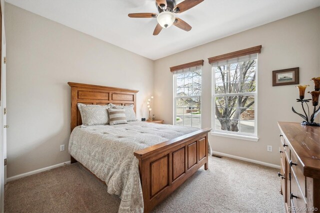bedroom featuring baseboards, ceiling fan, and light carpet