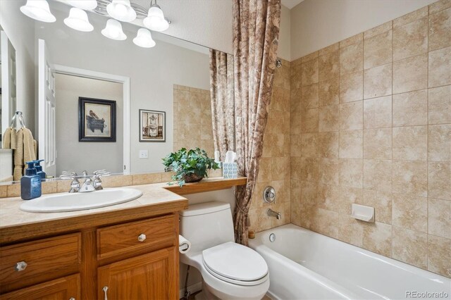 bathroom featuring vanity, toilet, and shower / bath combo with shower curtain