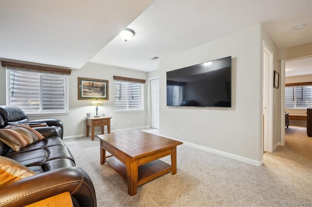 living room featuring baseboards, visible vents, and light carpet