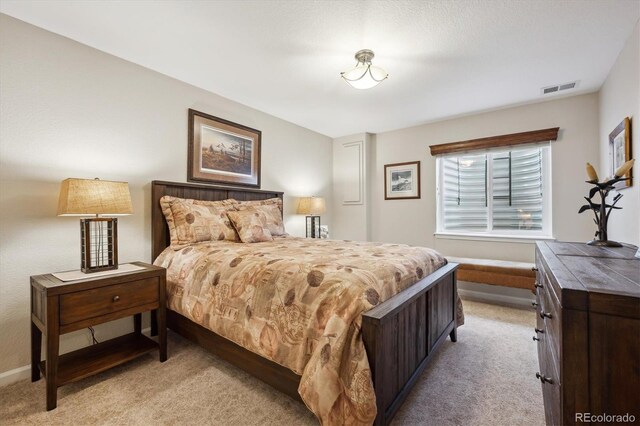 bedroom featuring visible vents, baseboards, and light carpet