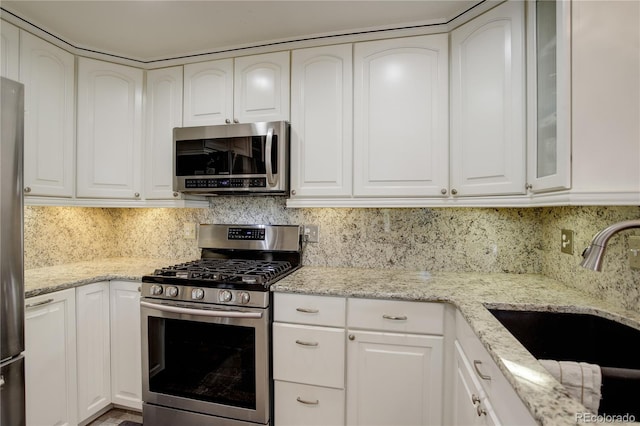 kitchen featuring white cabinets, stainless steel appliances, and sink