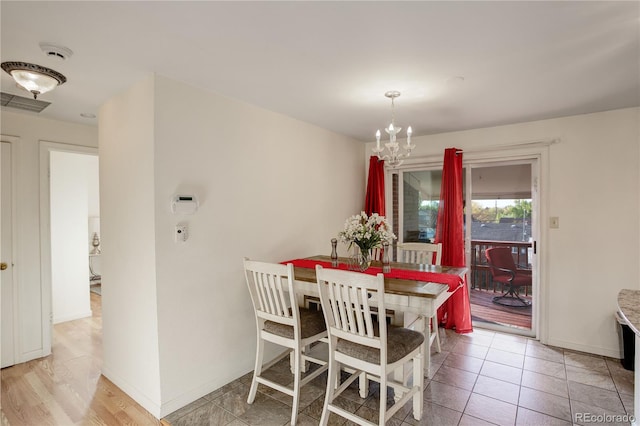 dining area featuring light hardwood / wood-style flooring and a chandelier