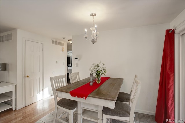 dining area with an inviting chandelier and wood-type flooring