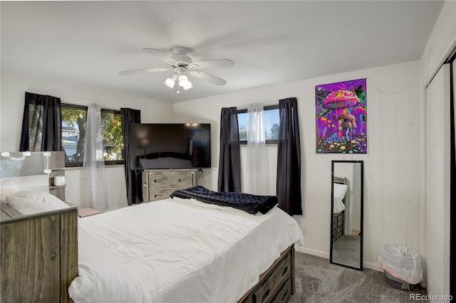 carpeted bedroom featuring multiple windows, ceiling fan, and a closet