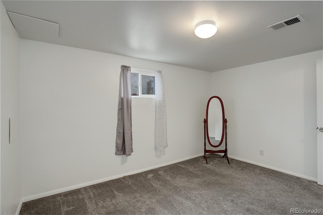 unfurnished room with carpet and a textured ceiling