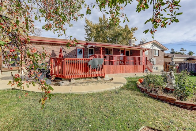 rear view of property with a lawn and a wooden deck