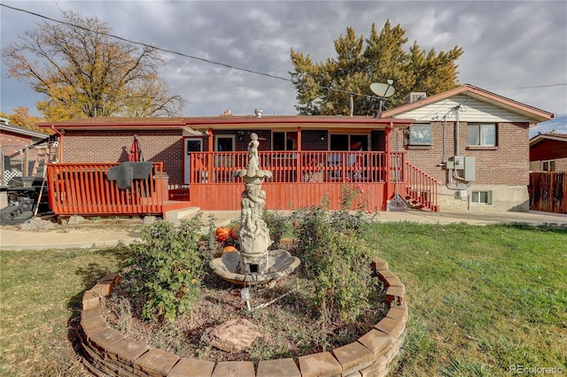 rear view of property with a lawn and a wooden deck