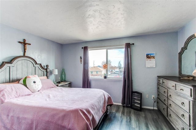 bedroom with dark hardwood / wood-style flooring and a textured ceiling