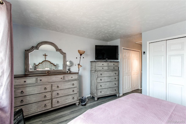 bedroom with dark hardwood / wood-style flooring, a textured ceiling, and two closets