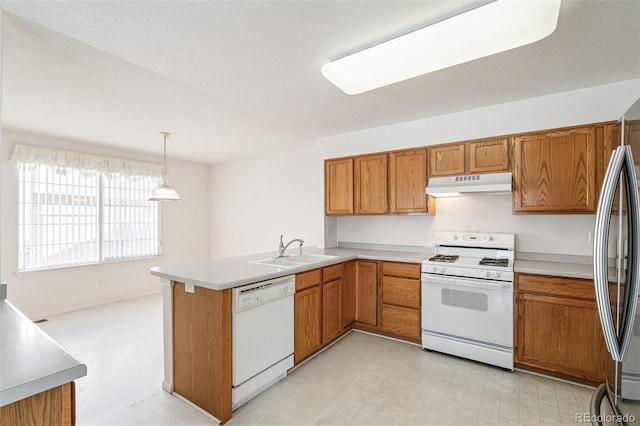 kitchen featuring sink, white appliances, a textured ceiling, decorative light fixtures, and kitchen peninsula