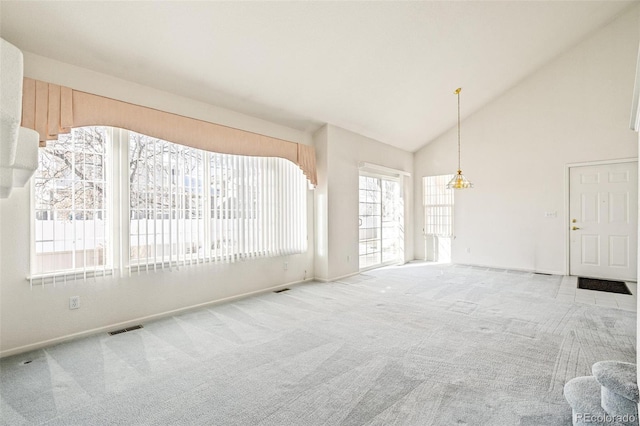 carpeted empty room with high vaulted ceiling