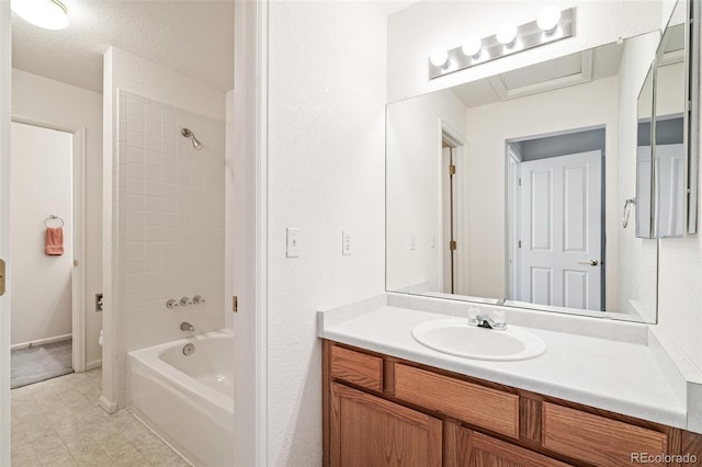 bathroom with tiled shower / bath combo and vanity