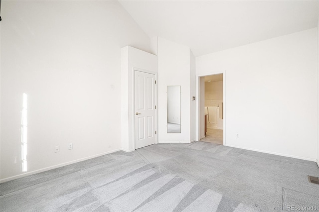 carpeted spare room featuring vaulted ceiling