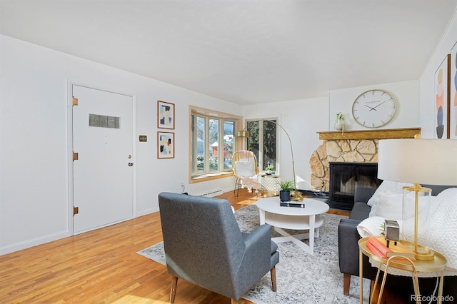 living room with a fireplace and light wood-type flooring