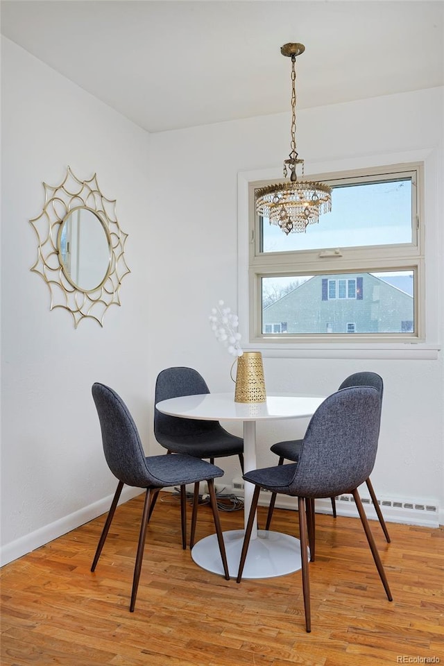 dining space featuring light hardwood / wood-style floors and a chandelier