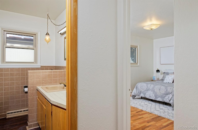 bathroom featuring vanity, wood-type flooring, and tile walls