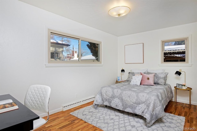 bedroom featuring wood-type flooring and baseboard heating