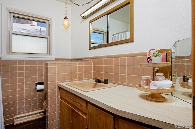 bathroom featuring vanity, tile walls, and baseboard heating