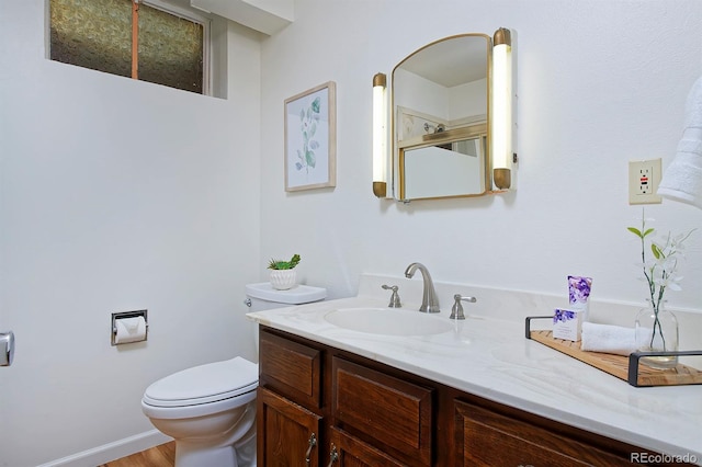 bathroom featuring vanity, wood-type flooring, and toilet