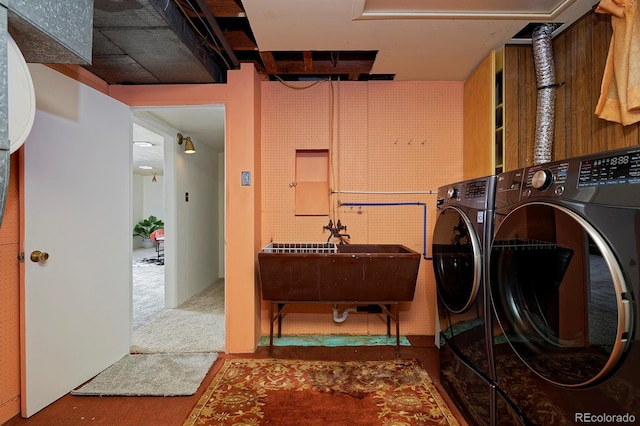 laundry room featuring carpet flooring, sink, and washing machine and clothes dryer