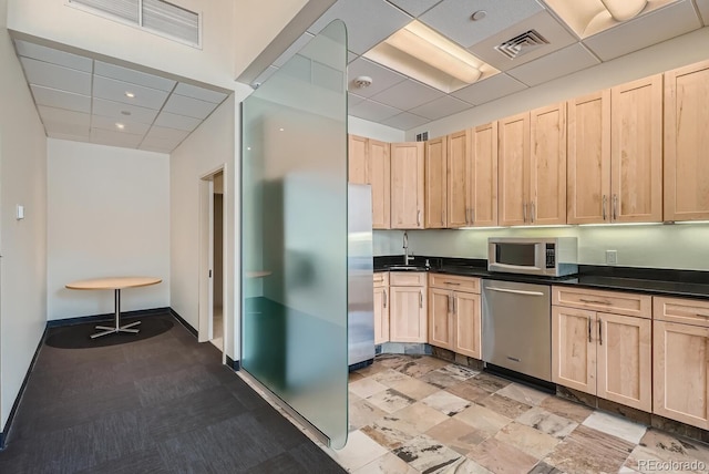 1499 Blake St Unit 1A & 1B, Denver, CO 80202 - kitchen featuring stainless steel appliances, light brown cabinets, dark countertops, a paneled ceiling, and a sink