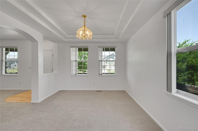 6910 E 131st Dr, Thornton, CO 80602 - carpeted empty room featuring a chandelier, arched walkways, and a tray ceiling
