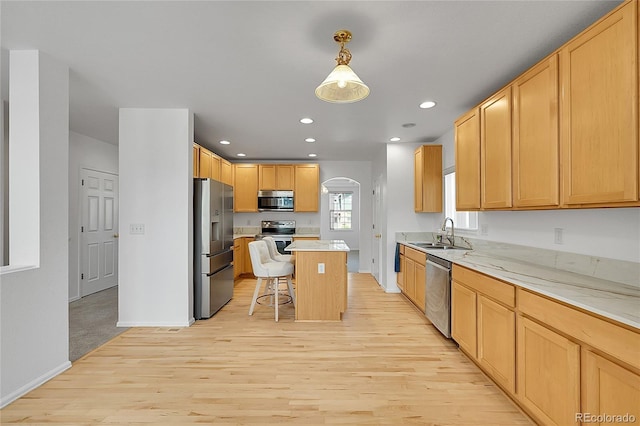 6910 E 131st Dr, Thornton, CO 80602 - kitchen featuring appliances with stainless steel finishes, light wood-style floors, a kitchen bar, light countertops, and recessed lighting