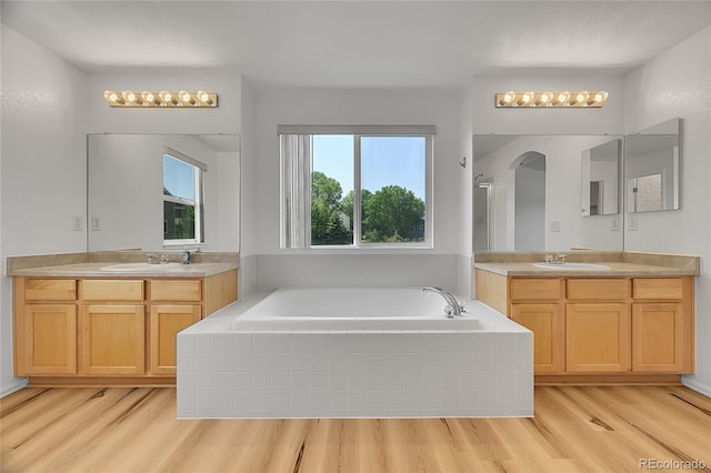 6910 E 131st Dr, Thornton, CO 80602 - bathroom featuring wood finished floors, a bath, and two vanities
