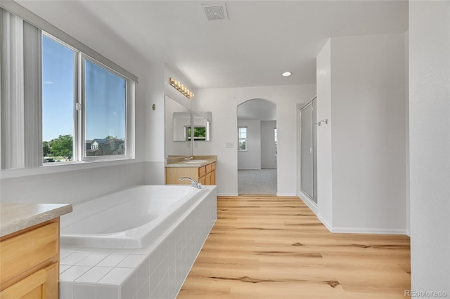 6910 E 131st Dr, Thornton, CO 80602 - full bath featuring vanity, a bath, wood finished floors, a stall shower, and recessed lighting