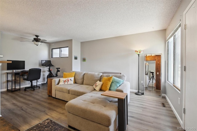 1830 Newland Ct Unit 101, Lakewood, CO 80214 - living area featuring a textured ceiling, wood finished floors, ceiling fan, a desk, and baseboards