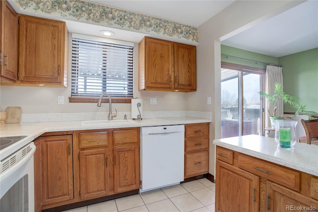 kitchen featuring white appliances, sink, and light tile patterned floors