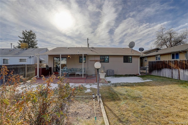 rear view of property with cooling unit, a yard, and a patio