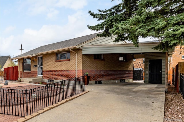exterior space with brick siding, driveway, a carport, and fence