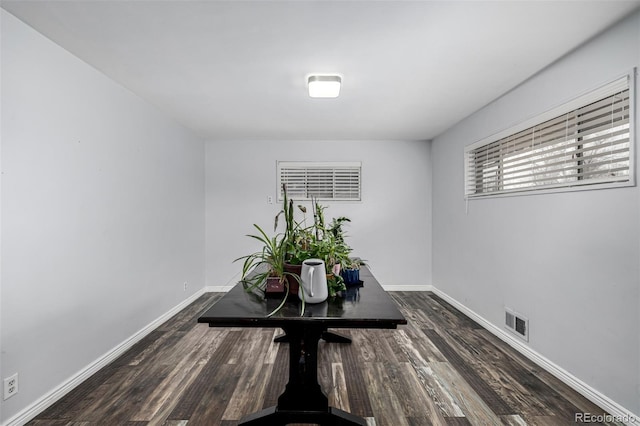 dining space featuring baseboards, wood finished floors, and visible vents