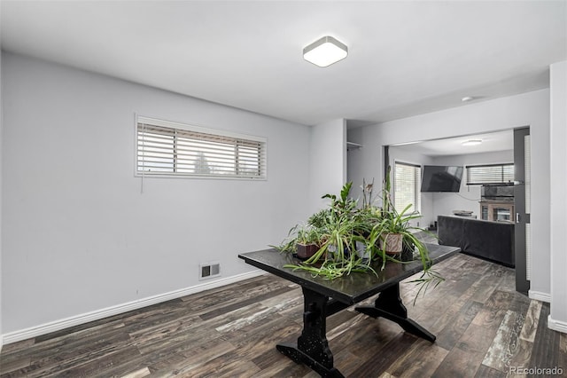 dining space featuring baseboards, wood finished floors, and visible vents
