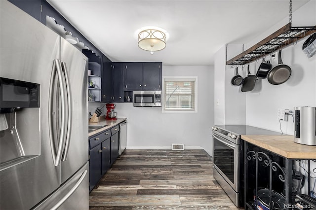kitchen with stainless steel appliances, light countertops, visible vents, dark wood-type flooring, and baseboards