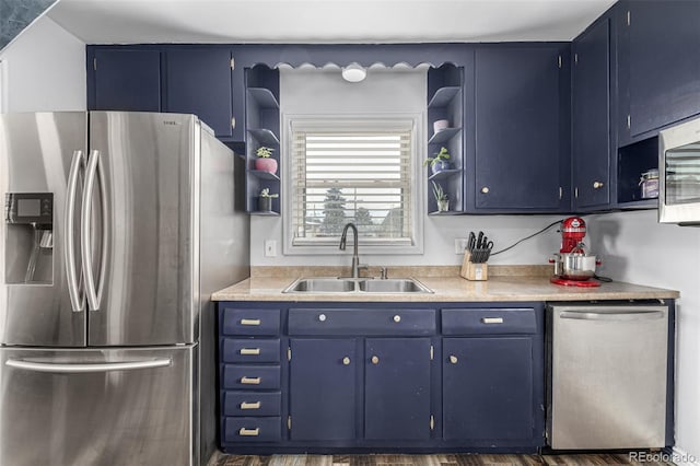 kitchen featuring blue cabinetry, open shelves, stainless steel appliances, and a sink