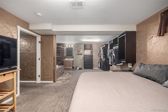 bedroom featuring carpet, visible vents, and a textured wall