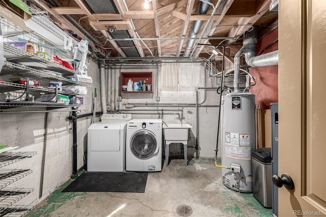 laundry area with washing machine and dryer, water heater, a sink, and laundry area