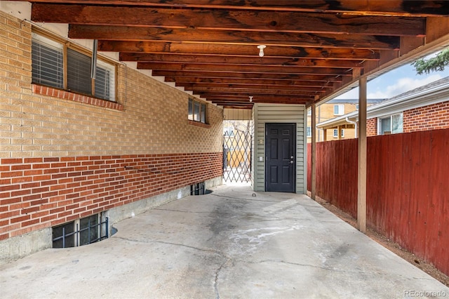 view of patio / terrace with a carport and fence