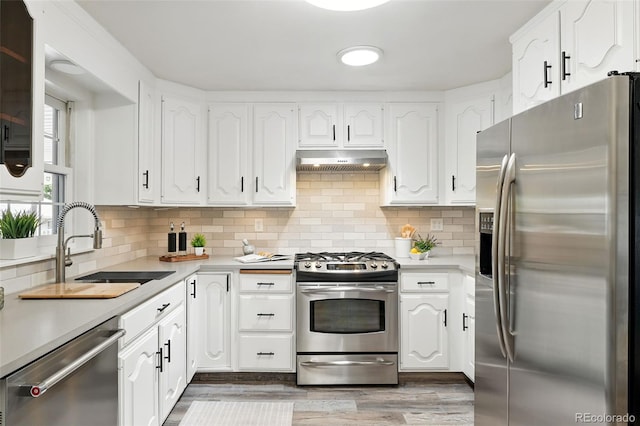 470 S Queen St, Lakewood, CO 80226 - kitchen featuring stainless steel appliances, under cabinet range hood, light countertops, and white cabinets