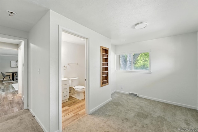 470 S Queen St, Lakewood, CO 80226 - unfurnished bedroom featuring carpet floors, connected bathroom, and a textured ceiling