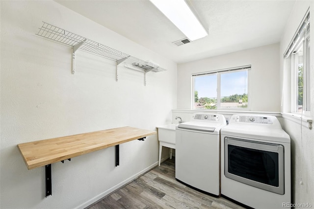 470 S Queen St, Lakewood, CO 80226 - laundry room featuring independent washer and dryer, light wood-type flooring, and plenty of natural light