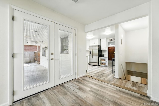 470 S Queen St, Lakewood, CO 80226 - doorway to outside featuring light wood finished floors and baseboards