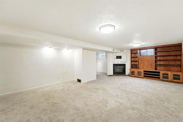 470 S Queen St, Lakewood, CO 80226 - unfurnished living room with a glass covered fireplace, light carpet, a textured ceiling, and a textured wall