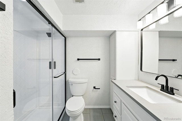 470 S Queen St, Lakewood, CO 80226 - bathroom featuring vanity, a stall shower, tile patterned flooring, a textured wall, and a textured ceiling