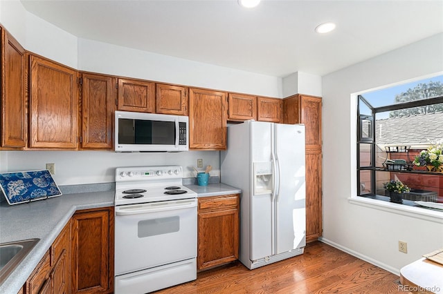 480 W Rockrimmon Blvd Unit D, Colorado Springs, CO 80919 - kitchen featuring white appliances, light wood-type flooring, brown cabinetry, and recessed lighting